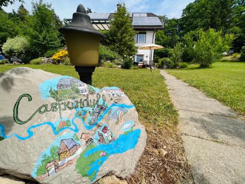 a rock sitting on the grass next to a sidewalk at Casparidyll in Sigmaringen