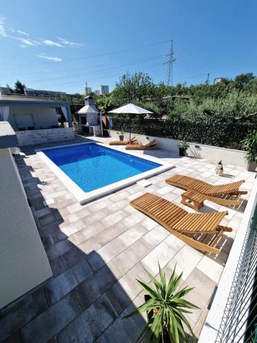a swimming pool with a bunch of chairs and a pool at Casa Bella in Split