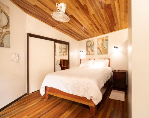 a bedroom with a bed with a wooden ceiling at Gamaí Monteverde Tiny House in Monteverde Costa Rica