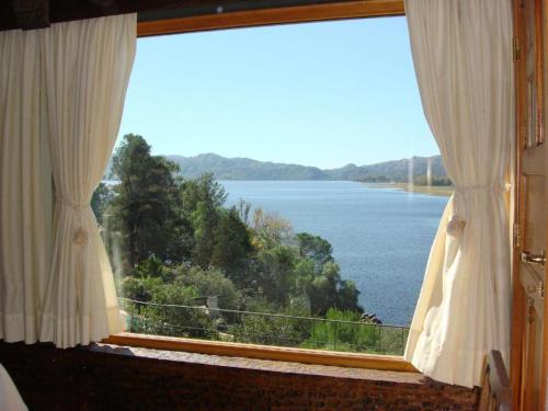ein Fenster mit Blick auf einen Wasserkörper in der Unterkunft casa con vista y bajada al lago in Villa Carlos Paz