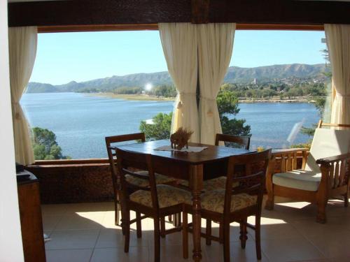 a dining room table with a view of a lake at casa con vista y bajada al lago in Villa Carlos Paz