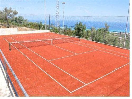 una pista de tenis con el océano en el fondo en Sant'Elia Country Village, en SantʼAgata di Militello