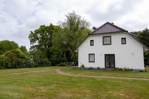 a white house with a green yard at Urlaubs-Appartement am Dorfrand in Wieck