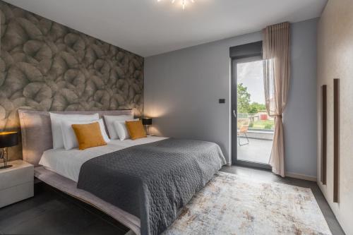 1 dormitorio con 1 cama grande y pared de piedra en Villa Emma-Louisa, en Žminj