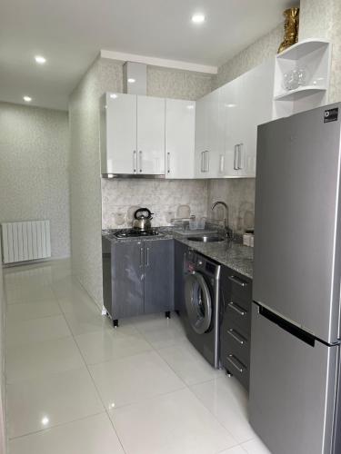 a kitchen with a refrigerator and a washing machine at ANDREA Villa in Batumi