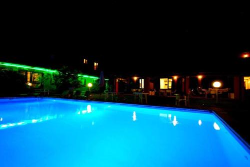 - une grande piscine avec des lumières bleues la nuit dans l'établissement Villa (home C) — Pool — Lake Idro, à Vesta