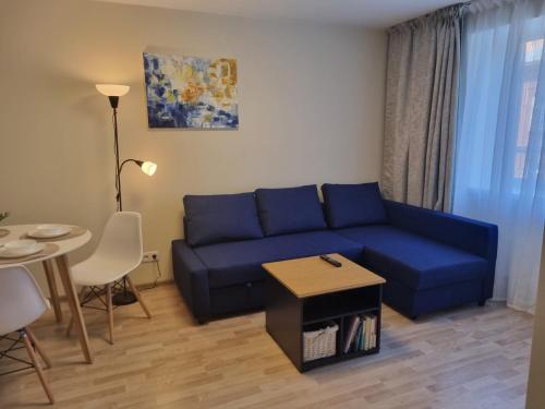 a living room with a blue couch and a table at Park Alice Apartment in Liepāja