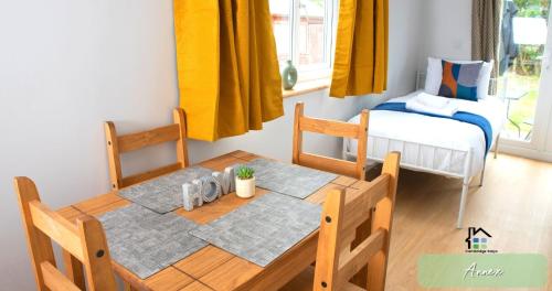 a dining room with a table and a bed at 4-5 Bedroom House Garden Lots of Parking 15 min to city Close to motorway in Girton