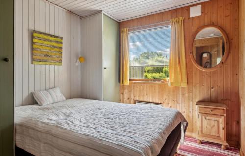 een slaapkamer met een bed, een spiegel en een raam bij 2 Bedroom Nice Home In Jgerspris in Jægerspris