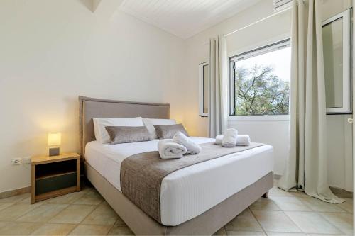 a bedroom with a large bed with towels on it at Gialos Holiday House in Agia Pelagia Chlomou