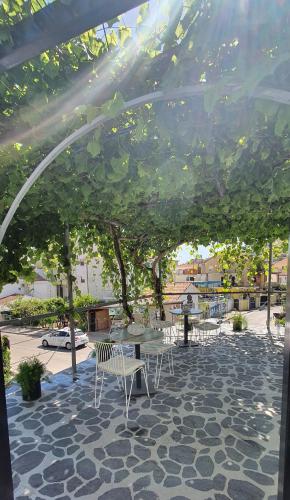 a patio with a table and chairs under a tree at Villa D&B Budva in Budva