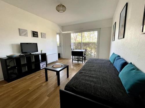 une chambre avec un lit et un salon avec une télévision dans l'établissement Studio Le Pied à Mer, à Houlgate