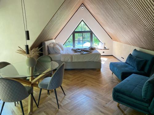 a attic bedroom with a bed and a table and chairs at Heinaläku puhkemaja loft in Paope