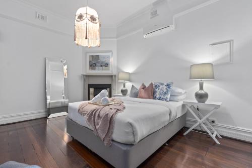 a white bedroom with a bed and a desk at Picture Perfect Create timeless treasures in Perth