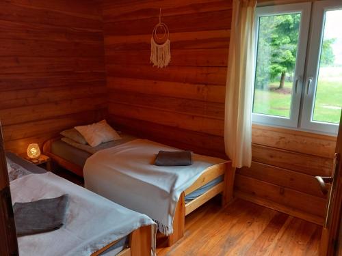 a room with two beds in a log cabin at Chatki Leśniczego in Bukowiec