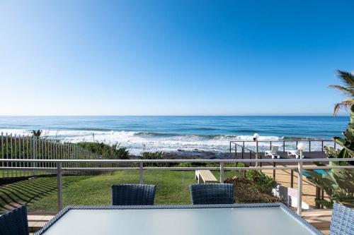 uma vista para a praia a partir da varanda de uma casa em Pebble Beach 26 em Ballito