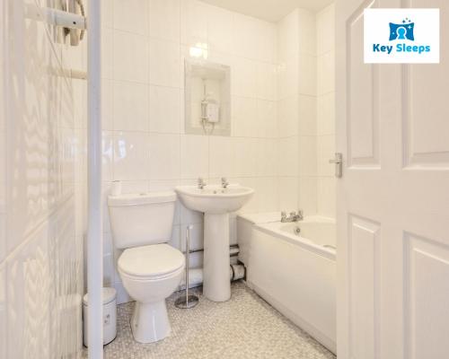 ピーターバラにあるFour Bedroom By Keysleeps Short Lets Peterborough With Free Parking Spacious Central Contractorのトイレと洗面台を備えた白いバスルーム