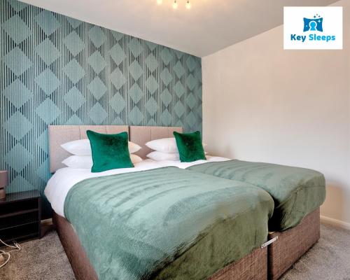ピーターバラにあるFour Bedroom By Keysleeps Short Lets Peterborough With Free Parking Spacious Central Contractorのベッドルーム1室(大型ベッド1台、緑のシーツ付)