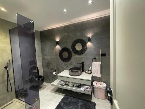 baño con lavabo y 2 espejos en la pared en 6BR SEA SALT POOL PRİVATE VİLLA en Sarıyer