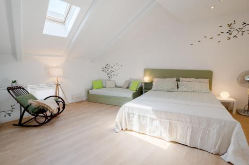 una camera bianca con un letto e un divano di La casa di Gabri Trieste centro a Trieste