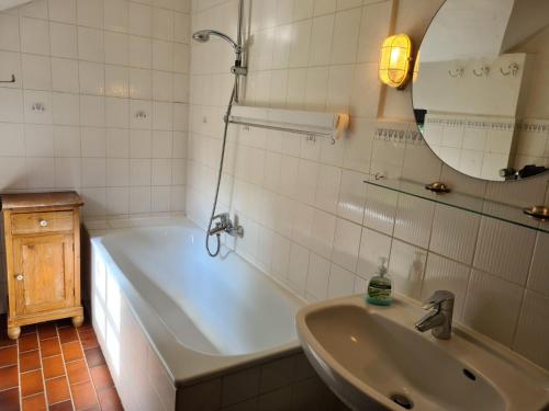 y baño con bañera, lavabo y espejo. en Bauernhaus Sehestedt, en Sehestedt