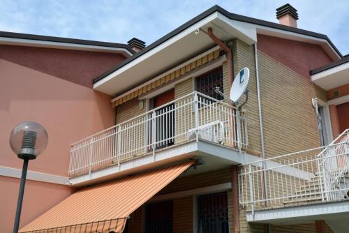 a house with a balcony and a street light at Appartamento Climatizzato con Piscina Ca' Aurelia in Lido di Savio