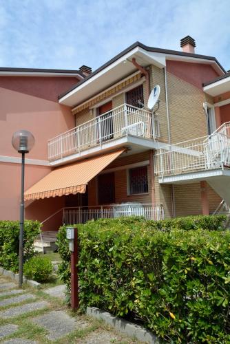 a building with a balcony and a satellite at Appartamento Climatizzato con Piscina Ca' Aurelia in Lido di Savio