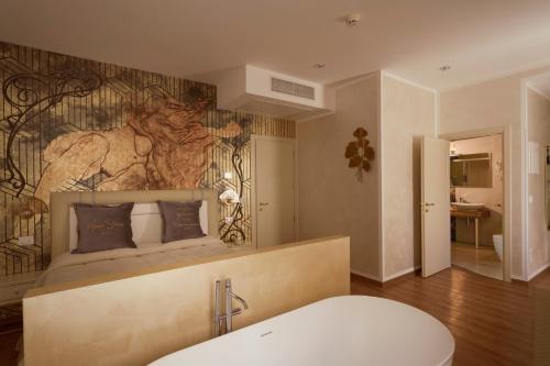 a bathroom with a bedroom with a bed and a tub at Amsterdam Suite Hotel & SPA in Rimini