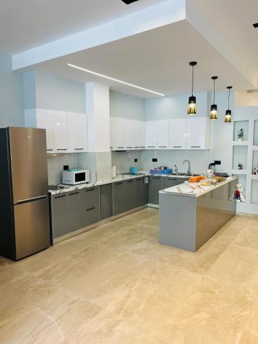 a large kitchen with white cabinets and stainless steel appliances at Central Boutique Hostel in Sarandë