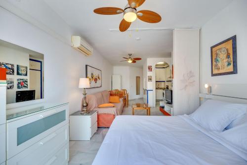 een slaapkamer met een wit bed en een woonkamer bij HomeForGuest Bright studio in La Carihuela near the beach in Torremolinos