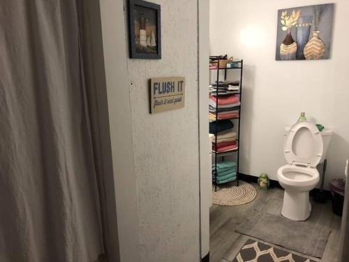 uma casa de banho com um WC e uma estante de livros em Sandy’s house 