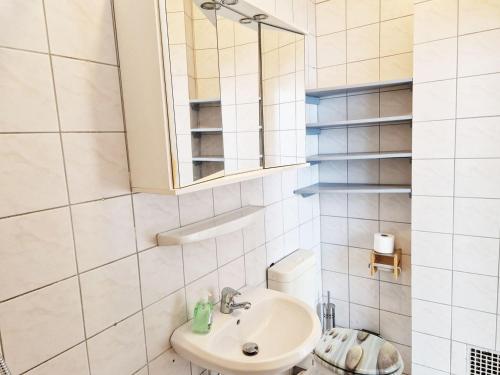 Baño blanco con lavabo y espejo en Work & Stay Apartments in Leverkusen, en Leverkusen