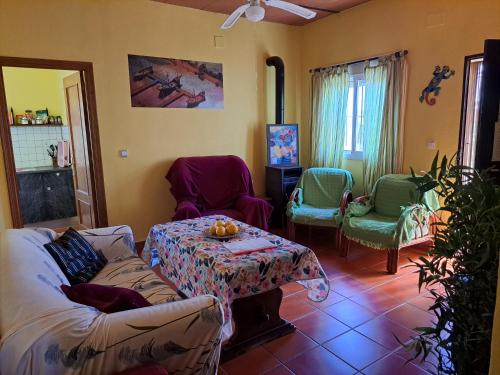 ein Wohnzimmer mit einem Sofa, Stühlen und einem Tisch in der Unterkunft Finca-Vallestares in Almonte