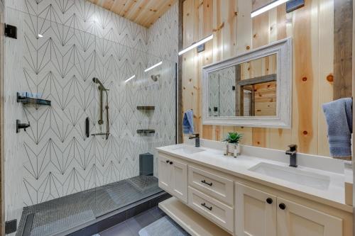 uma casa de banho com um lavatório, um espelho e um chuveiro em Family-Friendly Broken Bow Home with Deck and Grill! em Broken Bow