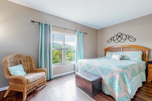 a bedroom with a bed and a chair and a window at Pigeon Forge Perfection in Pigeon Forge