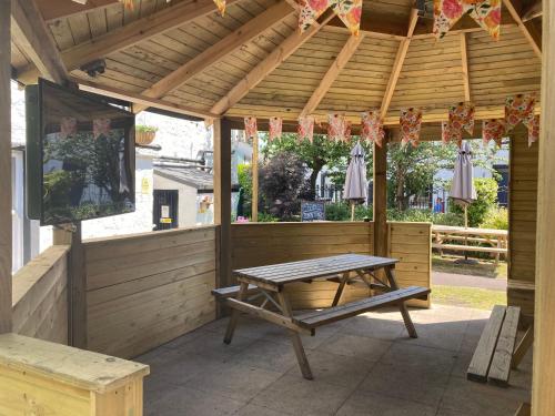 a wooden pergola with a picnic table on a patio at Old Swan in Skipton