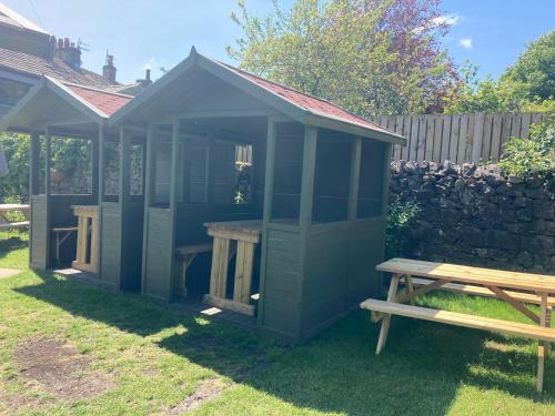 a blue shed with a bench in a yard at Old Swan in Skipton