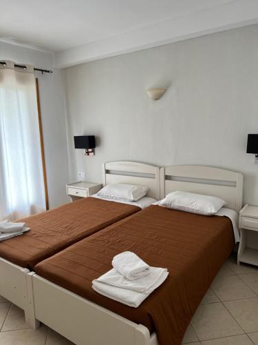 a hotel room with two beds with towels on them at Stavroula's House in Skiathos