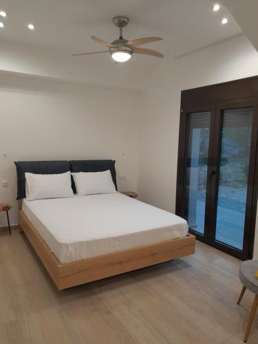 1 dormitorio con 1 cama y ventilador de techo en Central House 2, en Palaia Epidavros
