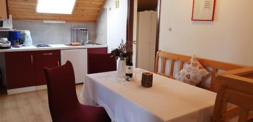 a dining room with a table and a kitchen at APARTMENT CHALET -BOHINJ- Pokljuka- Triglav National Park in Koprivnik v Bohinju