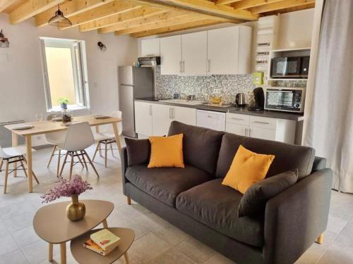 ein Wohnzimmer mit einem Sofa und einer Küche in der Unterkunft Maison avec Extérieur - Stationnement Gratuit in Périgueux