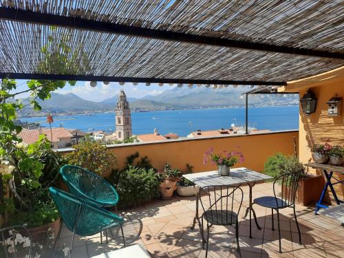 a patio with a table and chairs and a view of the water at B&B MilleQuattrocento in Gaeta