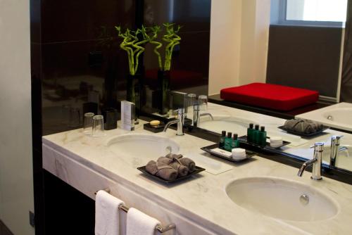 a bathroom with two sinks and a large mirror at Hotel Dighton in Oliveira de Azemeis