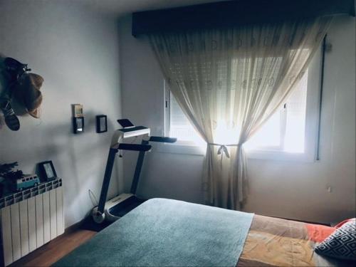 a bedroom with a bed and a window with a light at Piso Jùlia in Mataró