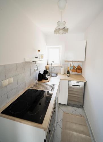 a small kitchen with a black stove top oven at L'infini Sea View apartments Zubovići in Zubovići