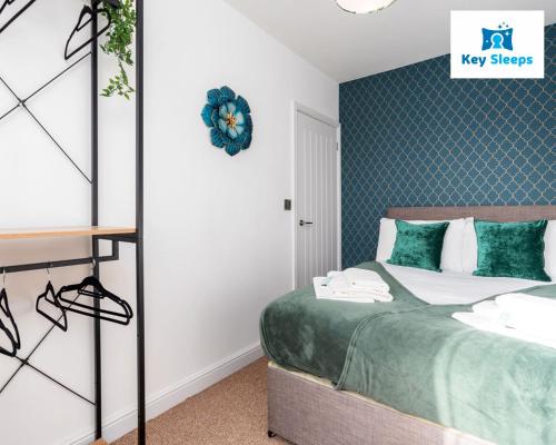 Schlafzimmer mit einem Bett mit grüner und weißer Bettwäsche in der Unterkunft Spacious Contractor House Leisure By Keysleeps Short Lets Derby With Free Parking in Derby