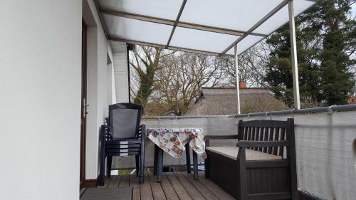awning over a porch with two chairs and a table at Ferienwohnung am Dorfrand in Wieck