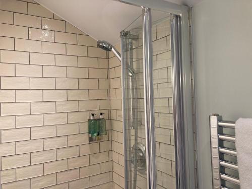 una doccia con una porta in vetro in un bagno di The Stork Hotel a Lancaster