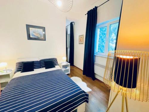 a bedroom with a blue and white bed and a window at Apartment Blue&Green in Kostrena