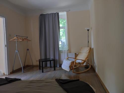 a bedroom with a bed and a chair and a window at St.Pauls apartment in Rīga